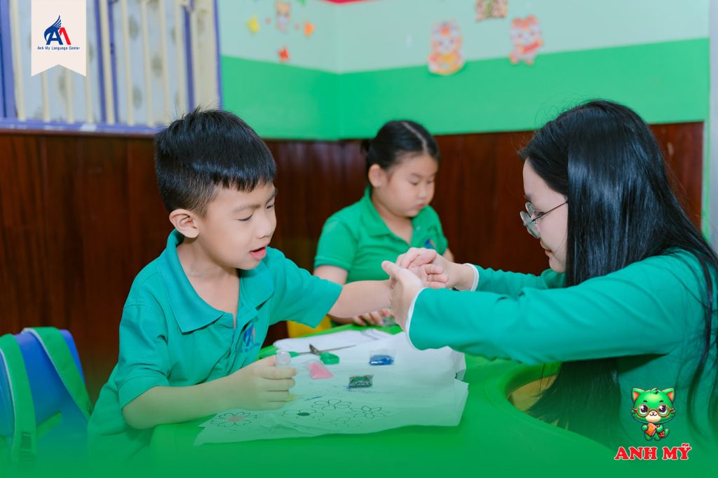 Hình 2: Không khí lớp học sáng tạo – học viên cùng giáo viên thực hiện hoạt động thủ công 8/3 và học tiếng Anh